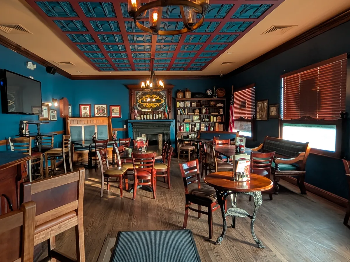 Tables, fireplace, bookshelves, and blue paneled ceiling inside the Robert Emmet Room